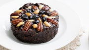 Pudding Lady Chocolate Fruit cake pictured with a jar of decadent chocolate sauce